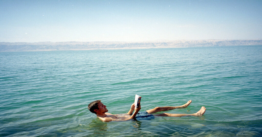 Imagen de una persona leyendo mientras flota en las aguas del Mar Muerto 