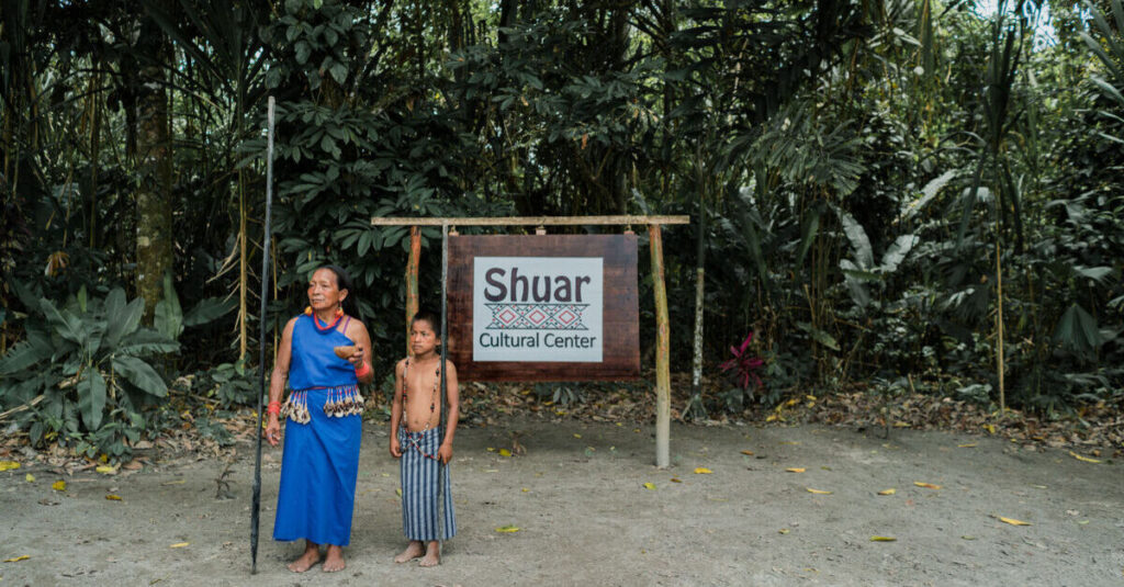Entrada al Centro Cultural Shuar, con dos personas pertenecientes a esta comunidad indígena del Amazonas ecuatoriano