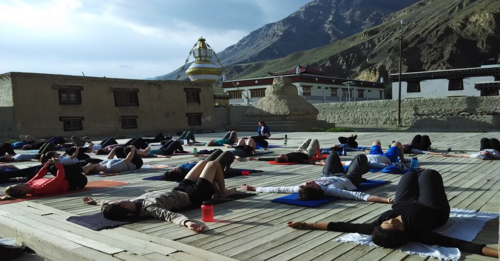 Un grupo de personas practica yoga en un monasterio de la India