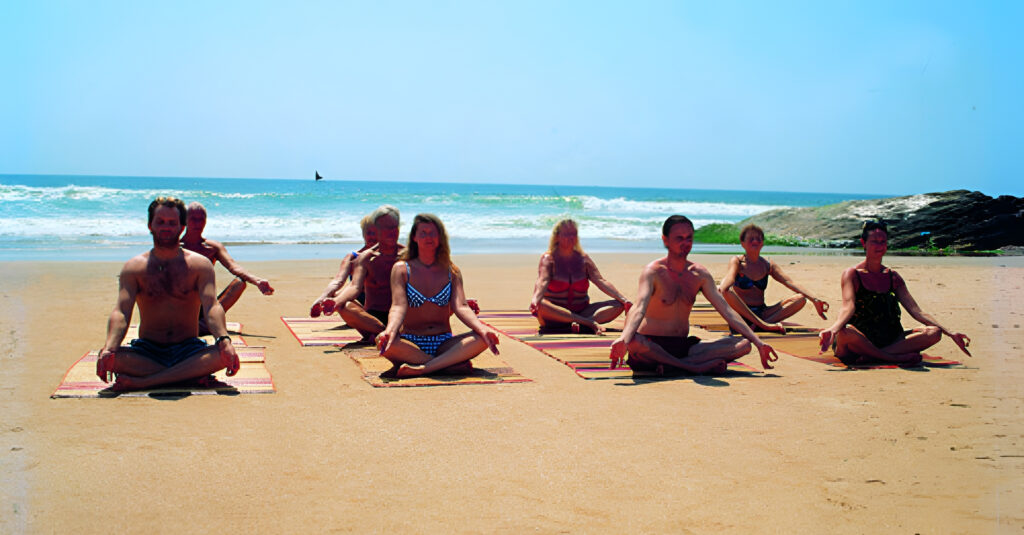 Gente practicando yoga en una playa de Kerala